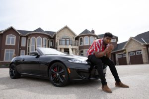 man sitting on black convertible coupe